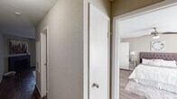 This single-story residence in Houston, TX offers a thoughtfully designed layout that maximizes functionality throughout its one-bedroom, one-bathroom floor plan. The open-concept living and dining area serves as the heart of the home, featuring dark hardwood-style flooring, neutral warm-toned walls, and a textured ceiling. A corner fireplace anchors the living space, while large sliding glass doors fitted with vertical blinds flood the room with natural light and provide outdoor access. The dining area flows seamlessly from the living room, positioned adjacent to a pass-through opening that connects to the kitchen.

The galley-style kitchen is efficiently organized with dark cabinetry lining both walls, granite-style countertops, a double stainless steel sink, and black appliances including a range and refrigerator. Track lighting overhead ensures the space is well-lit throughout.

The bedroom is generously sized with dark hardwood-style flooring, a ceiling fan, and ample natural light from a large window. It includes closet space and connects conveniently to the hallway. The full bathroom features a granite-style vanity countertop, a tub-shower combination, and coordinating dark cabinetry, maintaining the consistent design aesthetic found throughout the residence.