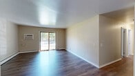 Located at 651 Schiller St in Sun Prairie, Wisconsin, this single-floor, 2-bedroom, 1-bathroom home offers a practical and comfortable layout. The open living area is finished with rich, dark hardwood-style flooring that extends seamlessly toward a sliding glass door, which fills the space with natural light and provides views of the outdoors. A wall-unit air conditioner and baseboard heating ensure year-round comfort throughout the home. The kitchen is efficiently laid out with warm wood cabinetry, granite-look countertops, stainless steel appliances including a full-size refrigerator, and a double sink — all set on light hardwood-style flooring. Both bedrooms are carpeted and feature ceiling fans with light fixtures, windows with blinds offering natural light and outdoor views, and baseboard heating. The primary bedroom includes a built-in sliding-door closet for ample storage. An additional closet provides further storage convenience. The bathroom is clean and functional, featuring a full tub-shower combination with a curved curtain rod. The overall design is straightforward and well-maintained, offering a comfortable living environment in a convenient Sun Prairie location.