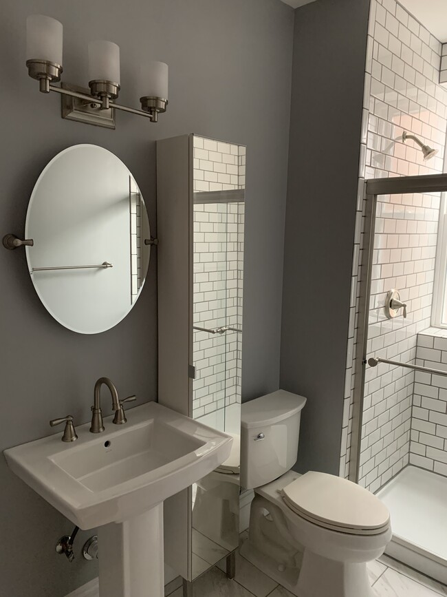 Bathroom with shower and mirrored storage cabinet - 4040 Russell Blvd