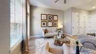 Located at 146 Roberts St in Asheville, NC, this 1-bedroom, 1-bathroom residence offers a thoughtfully designed open-concept layout with modern finishes throughout. Light wood-tone flooring flows seamlessly across the entire space, creating a warm and cohesive aesthetic.

The kitchen is a standout feature, boasting two-tone cabinetry — navy lower cabinets paired with natural wood upper cabinets — complemented by granite countertops, a subway tile backsplash, stainless steel appliances, and a central island with pendant lighting and bar seating. The kitchen opens directly into the living area, making the space ideal for entertaining.

The living room is bright and airy, with large windows and a balcony-access door that flood the space with natural light and provide outdoor views. A ceiling fan adds to the comfort of the room.

The bedroom is generously proportioned, wrapped on two sides by wide windows that offer abundant natural light and neighborhood views, and is equipped with a ceiling fan and ample closet storage — three closets are included throughout the residence.

The bathroom features dark cabinetry contrasting with granite countertops, an undermount sink, a large vanity mirror, and a glass-enclosed shower. Additional conveniences include in-unit laundry, completing this functional and stylish Asheville residence.