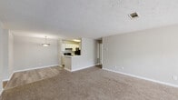 Located at 5200 N Henry Blvd in Stockbridge, GA, this well-appointed two-bedroom, two-bathroom residence offers a thoughtfully designed single-floor layout. The open-concept living and dining area is anchored by plush carpeting and a neutral color palette, creating a warm and inviting atmosphere. A pendant light fixture adds a decorative touch, while the textured ceilings lend classic character throughout the home.

The kitchen is positioned adjacent to the living area and features white cabinetry, black appliances including a range and refrigerator, a peninsula with a light-toned countertop ideal for casual dining, and durable hardwood-style flooring that contrasts seamlessly with the carpeted living spaces.

The spacious primary bedroom is filled with natural light courtesy of multiple windows fitted with blinds, and includes a ceiling fan for added comfort. Each bedroom offers closet storage to maximize organization. The second bedroom also provides ample space with its own closet and natural light.

Both bathrooms are clean and functional, featuring tub-shower combinations, marble-patterned countertops, and wood-style flooring. The layout provides convenient access between the bedrooms and their respective bathrooms. Overall, this residence delivers a comfortable and practical living experience in a straightforward, move-in-ready setting.