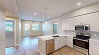 Located in Scottsdale, AZ, this well-appointed 2-bedroom, 2-bathroom single-floor residence offers a thoughtfully designed open-concept layout. The kitchen serves as the heart of the home, showcasing crisp white cabinetry, a marble-look quartz peninsula with an undermount sink, stainless steel appliances including a refrigerator, range, microwave, and dishwasher, and a tasteful tile backsplash. Pendant lighting above the peninsula adds a modern touch, while recessed lighting illuminates the space throughout. The kitchen flows seamlessly into the living area, which features light wood-style plank flooring and a glass door providing natural light and outdoor access. The bedrooms offer a comfortable retreat; the primary bedroom includes a ceiling fan, a window with outdoor views, and access to a walk-in closet with built-in shelving and hanging rods. The second bedroom features plush carpeting and ample natural light. The primary bathroom is generously sized with a dual-sink quartz vanity, white cabinetry, a walk-in shower, and wood-style flooring. The second bathroom mirrors the same clean aesthetic with a quartz vanity and a soaking tub with shower. Neutral tones and modern finishes throughout lend the space a bright, cohesive ambiance.