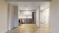 Located at 257 Lisgar St in Ottawa's vibrant Centretown neighbourhood, this one-bedroom, one-bathroom unit offers a thoughtfully designed layout that maximizes every square foot of its compact footprint. Light wood-style plank flooring runs throughout the entire space, creating a cohesive and contemporary feel.

The renovated kitchen is a standout feature, showcasing two-tone cabinetry with crisp white uppers and matte grey lowers, complemented by light stone countertops and a sleek black-finish faucet. Stainless steel appliances — including a full-size refrigerator, gas range, and dishwasher — complete the functional and stylish cooking space. Recessed lighting overhead adds a clean, modern touch.

The living area is bathed in natural light through a large window, with baseboard heating units lining the walls for year-round comfort. Neutral tones throughout keep the space feeling open and airy.

The bedroom is a well-proportioned private retreat with its own window and consistent light flooring, offering a calm and quiet environment. The bathroom is finished in a clean, contemporary style with a soaking tub, white tile surround, a wide vanity with stone countertop, and a mirrored medicine cabinet with modern hardware. Black matte accents throughout tie the design together cohesively.