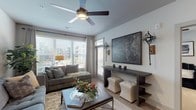 Located at 2312 Bristol Creek Drive in Morrisville, NC, this well-designed single-floor residence offers a thoughtfully planned layout with modern finishes throughout. The open-concept kitchen serves as a central hub, showcasing granite countertops, a large center island with bar seating, two-tone cabinetry with white upper and dark lower cabinets, a subway tile backsplash, stainless steel appliances, pendant lighting, and wood-look flooring that flows seamlessly throughout the main living areas. The living room is bright and inviting, featuring large windows with abundant natural light, access to an outdoor balcony, and a ceiling fan overhead. Two bedrooms provide comfortable retreats, each with plush carpeting, ceiling fans, and generous windows. The primary bathroom is particularly spacious, offering a long granite-topped vanity with dual sinks, dark cabinetry, a glass-enclosed shower, a separate soaking tub, wood-look flooring, and access to a walk-in closet. The secondary bathroom mirrors the refined aesthetic with a granite vanity, a tub-shower combination, and its own walk-in closet. Together, these spaces create a cohesive, contemporary living environment with high-quality finishes and a clean, modern ambiance.