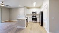 This 940-square-foot, 1-bedroom, 2-bathroom apartment at 25335 Alessandro Blvd in Moreno Valley, CA offers a well-designed single-floor layout. The kitchen is a standout feature, equipped with stainless steel appliances including a gas range, built-in microwave, dishwasher, and refrigerator, complemented by white shaker-style cabinetry, light countertops, and a kitchen island with additional workspace. Light wood-style flooring runs throughout the unit, lending a clean and cohesive aesthetic. The spacious 250-square-foot primary bedroom features multiple windows that bring in natural light, a ceiling fan, and direct access to a private balcony through sliding glass doors. The living room also opens to the balcony, extending the living space outdoors. Both bathrooms are finished with white vanities, large mirrors, and tub-shower combinations. A dedicated walk-in closet with wire shelving provides ample storage. The hallway connects all rooms efficiently within the thoughtful floor plan. Neutral wall tones and modern finishes throughout give the unit a bright, contemporary feel.