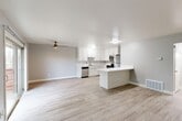 Located at 1745 Cormorant Way in Sacramento, CA, this single-floor, one-bedroom, one-bathroom home offers a thoughtfully designed layout with modern finishes throughout. The open-concept living and kitchen area forms the heart of the home, featuring light wood-style flooring, neutral gray walls, and a ceiling fan that enhances airflow and comfort. A sliding glass door floods the living space with natural light. The kitchen is well-appointed with white shaker-style cabinetry, bright white countertops, a stainless steel refrigerator, range, built-in microwave, and dishwasher. A peninsula with an extended countertop provides additional workspace and a casual seating area, seamlessly connecting the kitchen to the living room. The spacious primary bedroom is finished with plush carpeting, a ceiling fan with light fixture, and a sliding glass door opening to a private wooden balcony with outdoor views. A full-size closet provides ample storage. The bathroom features wood-style flooring, a white vanity, a tub-shower combination, and a window that brings in natural light. A hallway connects all rooms efficiently, completing this clean and functional home.