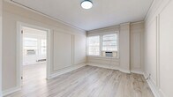 Located on the third floor at 4961 Laclede Ave in St. Louis's Central West End neighborhood, this 2-bedroom, 1-bathroom unit blends classic building character with modern updates. Light wood-tone laminate flooring runs consistently throughout the space, creating a cohesive and airy feel. The layout is efficiently organized, connecting the kitchen, living areas, and bedrooms in a logical flow.

The kitchen is galley-style, featuring white shaker cabinetry, light quartz countertops, a white subway tile backsplash, and stainless steel appliances including a gas range, refrigerator, and dishwasher. The clean, bright finishes maximize the sense of space in this functional area.

The primary bedroom is generously sized relative to the unit, with paneled wall detailing, large windows allowing natural light, and a built-in shelved closet providing organized storage. The second bedroom is a quieter, more intimate space, also featuring light flooring and a classic cast-iron radiator.

The bathroom retains notable vintage character, highlighted by bold black-and-white patterned tile flooring, a pedestal sink, a medicine cabinet with mirror, and a soaking tub with shower. Cast-iron radiators throughout the unit reflect the building's historic charm while providing efficient heating.