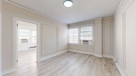 Located on the third floor at 4961 Laclede Ave in St. Louis's Central West End neighborhood, this 2-bedroom, 1-bathroom unit blends classic building character with modern updates. Light wood-tone laminate flooring runs consistently throughout the space, creating a cohesive and airy feel. The layout is efficiently organized, connecting the kitchen, living areas, and bedrooms in a logical flow.

The kitchen is galley-style, featuring white shaker cabinetry, light quartz countertops, a white subway tile backsplash, and stainless steel appliances including a gas range, refrigerator, and dishwasher. The clean, bright finishes maximize the sense of space in this functional area.

The primary bedroom is generously sized relative to the unit, with paneled wall detailing, large windows allowing natural light, and a built-in shelved closet providing organized storage. The second bedroom is a quieter, more intimate space, also featuring light flooring and a classic cast-iron radiator.

The bathroom retains notable vintage character, highlighted by bold black-and-white patterned tile flooring, a pedestal sink, a medicine cabinet with mirror, and a soaking tub with shower. Cast-iron radiators throughout the unit reflect the building's historic charm while providing efficient heating.