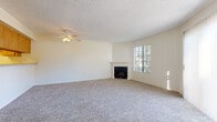 Located at 11819 Central Ave in Chino, California, this single-floor home offers a well-organized layout designed for comfortable everyday living. The expansive living room serves as the heart of the space, featuring plush wall-to-wall carpeting, a ceiling fan with light fixture, a classic white-mantled fireplace, and generous natural light streaming through large windows. A sliding glass door opens to the outdoors, further brightening the room. Adjacent to the living area, a dining space connects to the kitchen via a practical pass-through counter, providing an open and sociable flow between rooms. The kitchen is fully equipped with warm wood cabinetry, granite-style countertops, white appliances including a gas range, microwave, and dishwasher, and easy-to-clean tile flooring. The bedrooms are carpeted and well-proportioned, each featuring natural light from windows and full-width sliding closets offering ample storage. The bathroom is appointed with a dual-sink vanity featuring speckled countertops, a large wall mirror, tile flooring, and a separate shower area. Textured ceilings are found throughout the home, adding a consistent finish. The overall ambiance is clean, neutral, and move-in ready.