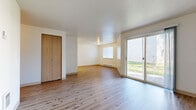 Located at 3000 NE 109th Ave in Vancouver, Washington, this single-floor 2-bedroom, 1-bathroom residence offers a practical and comfortable layout. The open living room is a welcoming space featuring light hardwood-style flooring, neutral cream-toned walls, and a sliding glass door that fills the room with natural light and provides outdoor access. A baseboard heating system and a window offer additional light and comfort to the living area, which also includes a closet for convenient storage.

The kitchen is efficiently designed with white cabinetry accented by wood trim, light hardwood flooring, and a full suite of appliances including a refrigerator, electric range, and a sink with ample counter space. Upper and lower cabinetry provide generous storage throughout.

Both bedrooms are finished with warm, neutral carpet and feature good natural light. The primary bedroom offers a well-sized closet with built-in shelving and hanging rods. The second bedroom also includes a closet and a window with blinds.

The bathroom is neatly appointed with light hardwood-style flooring, a full tub-shower combination, a toilet, and a long vanity with an extended countertop and a large mirror, providing ample prep space. Overall, the residence presents a clean, functional, and move-in ready environment.