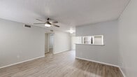 Located at 6101 Westgate Dr in Orlando, FL, this two-bedroom, one-bathroom residence offers a well-designed single-floor layout that maximizes every square foot of its compact footprint. Light wood-style flooring runs throughout, lending a clean, cohesive look to all living areas.

The open living room is bright and airy, featuring large windows with blinds that invite natural light, a ceiling fan with light fixture, and a textured ceiling. It flows seamlessly into the kitchen via a pass-through peninsula bar. The kitchen is well-appointed with white shaker-style cabinetry, light countertops, and a full suite of stainless steel appliances including a refrigerator, range, and dishwasher.

Both bedrooms are comfortably proportioned, each offering a sliding closet, ceiling fan, and neutral gray walls that complement the light flooring. The primary bedroom provides a generous layout suitable for a full furniture arrangement.

The bathroom is clean and functional, featuring a wide vanity with white cabinetry, a large mirror, and a shower-tub combination. A dedicated laundry room houses a full-size washer and dryer alongside open wire shelving and a water heater, adding practical convenience. A connecting hallway ties all spaces together efficiently.