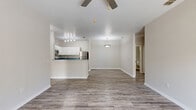 Located at 4017 Crosswind Court in Melbourne, Florida, this single-story, 2-bedroom, 2-bathroom home offers a well-designed layout with a clean, neutral aesthetic throughout. The open-concept living and kitchen area serves as the heart of the home, featuring durable wood-look plank flooring, a ceiling fan, and a pendant light over the dining space. The kitchen is outfitted with white cabinetry, a dark contrasting countertop, stainless steel appliances including a refrigerator and microwave, a breakfast bar, and a dedicated overhead track lighting fixture. A sliding glass door in the living area fills the space with natural light and provides direct access to the outdoors, offering pleasant views of mature landscaping. Both bedrooms are carpeted, equipped with ceiling fans, and receive ample natural light — the primary bedroom features a sliding glass door to the exterior, while the second bedroom includes a large window. Each bedroom is served by its own closet, with wire shelving systems for organized storage. The two bathrooms include wood-look flooring and a tiled tub-and-shower combination with brushed nickel fixtures. Additional utility areas house a water heater, rounding out the functional layout of this well-maintained Florida home.