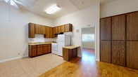 Located at 8522 Glenoaks Blvd in Sun Valley, Los Angeles, this one-bedroom, one-bathroom unit offers a well-organized and functional layout across a single floor. The living area is highlighted by warm-toned hardwood flooring and notably high ceilings that lend an open, airy feel to the space despite its compact footprint. Natural light filters in through a window, brightening the interior.

The kitchen is equipped with rich wood cabinetry providing generous upper and lower storage, light-toned countertops, a double-basin sink, a gas range, a full-size refrigerator, and a built-in microwave above the stove. Tile flooring runs throughout the kitchen area, complementing the wood floors in the living and sleeping spaces. A freestanding kitchen island adds additional workspace and versatility.

The bedroom is a comfortable size, featuring the same warm hardwood flooring, soaring walls, and a full-width sliding-door closet for ample storage. A wall-mounted light fixture adds a practical touch.

The bathroom is clean and straightforward, with tile flooring, bright white walls, and a shower-tub combination enclosed by frosted sliding glass doors. The overall ambiance of the unit is bright, neutral, and move-in ready.