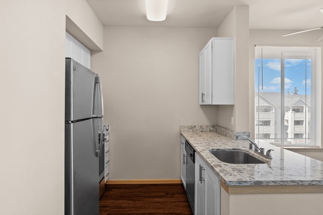 A sleek kitchen with updated finishes and bright natural light. - Alder Court Apartments