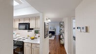 Located at 3320 Edenborn Ave in Metairie, Louisiana, this single-floor, one-bedroom, two-bathroom residence offers a well-organized and efficiently designed layout. The living room features warm hardwood-style flooring, neutral walls, and a glass-paned exterior door that invites natural light and provides access to an outdoor area. The open flow continues into the dining area, which is illuminated by a classic chandelier and adjoins a pass-through kitchen with light granite-style countertops, white appliances, and a functional bar-style counter connecting to the dining space. The bedroom is a comfortable retreat, carpeted for warmth, and equipped with a ceiling fan with light fixture, a double-door closet, and a window for natural light. Two hallways connect the main living areas to the bathrooms, one of which features a tub/shower combination with wood-style flooring and overhead cabinetry for storage. The second bathroom is accessible off the hallway and includes clean, simple finishes. Throughout the unit, the light-toned walls and consistent flooring create a cohesive, airy ambiance. The layout maximizes every square foot, making it a practical and comfortable home in a convenient Metairie location.