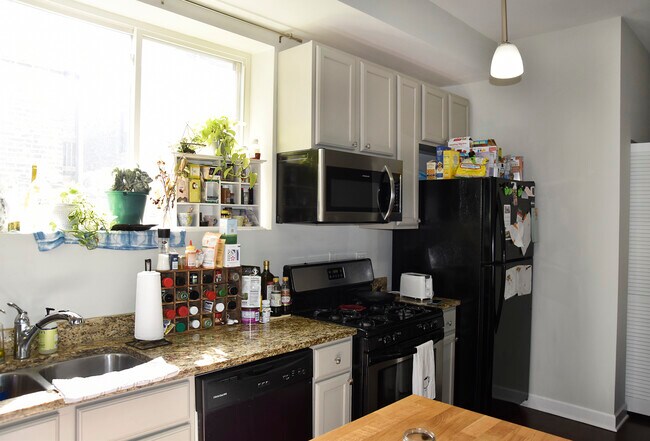 Kitchen includes microwave, dishwasher, refrigerator, granite countertops, and island - 2315 W Rice St
