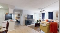 Located at 2701 W Waters Ave in Tampa, Florida, this 2-bedroom, 2-bathroom residence offers a practical and comfortable single-floor layout. The open living and dining area is finished with light ceramic tile flooring and features a ceiling fan, large windows that invite natural light, and direct sightlines to both bedrooms. The living room provides a welcoming space with ample room for seating, while the adjacent dining area accommodates a full table set and is positioned near the front entry. The galley-style kitchen is outfitted with white shaker cabinetry, light countertops, a double basin sink, stainless steel appliances, and tile flooring — offering an efficient and clean workspace. Both bedrooms feature wood-look plank flooring and closet storage; the primary bedroom includes a walk-in closet, while the second bedroom is served by a spacious bi-fold closet. Each bathroom has its own distinct character: one features a tub-shower combination with tile surround and white cabinetry, while the second offers a shower with a bold decorative aesthetic and a well-lit vanity. A hallway connects the main living areas to the bedrooms and bathrooms, completing this efficiently designed Tampa residence.