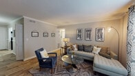 Located at 1355 Graves Rd in Norcross, GA, this thoughtfully appointed single-floor apartment showcases a cohesive blend of modern updates and comfortable design throughout its well-organized layout. The living room serves as the heart of the home, featuring warm hardwood-style flooring, crown molding, and neutral gray walls that provide an inviting backdrop for relaxed living. A large sectional sofa, accent armchair, and glass-top coffee table complete the space, while bold black-and-white geometric artwork adds a striking visual element. The kitchen has been tastefully updated with crisp white shaker cabinetry, marble-look countertops, a classic subway tile backsplash, and a black range, creating a clean and functional cooking space. The dining area stands out with elegant wainscoting, striped wall detailing, a pendant light fixture, and crown molding, lending the room a distinct, refined character. Both bedrooms offer carpeted flooring and ceiling fans, with closet storage and softly styled décor that creates a restful atmosphere. The bathroom features wood-look tile flooring, a white vanity, and a tub-shower combination with a window for natural light. Throughout the unit, consistent neutral tones and carefully chosen finishes contribute to a cohesive, move-in-ready aesthetic.