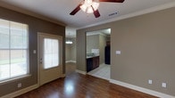 This two-story home offers three bedrooms and two and a half bathrooms across a well-organized layout designed for comfortable everyday living. The main level features an open entry area with rich hardwood-style flooring, crown molding, and a ceiling fan, flowing naturally into the adjacent kitchen. The kitchen is equipped with warm-toned wood cabinetry, tile countertops, a tiled backsplash, black appliances including a full-size refrigerator, and a convenient pantry closet. A pendant light fixture highlights the dining area nearby, and a half bathroom is also located on this level.

Upstairs, the bedrooms are finished with neutral carpet and ceiling fans, providing a comfortable and quiet retreat. Each room receives natural light through blinds-fitted windows. The primary bedroom connects to a full bathroom featuring a soaking tub, tiled flooring, and wood vanity cabinetry. A second full bathroom serves the remaining bedrooms and includes a tub-shower combination, tiled floors, and a wood vanity. Throughout the home, a consistent warm taupe color palette and clean white trim create a cohesive, understated aesthetic.