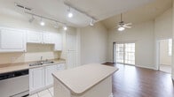 Located at 7895 Shadow Creek Dr in Hamilton, Ohio, this two-story home offers a well-designed layout across two floors. The main level features an open-concept living and dining area with soaring vaulted ceilings, a ceiling fan, and rich hardwood-style flooring. Sliding glass doors fill the living room with natural light and provide access to an outdoor balcony. The kitchen is outfitted with white cabinetry, stainless steel appliances including a refrigerator and range, tile flooring, track lighting, and a peninsula island ideal for casual dining or meal prep. A dedicated dining area and entrance complete the main level. Upstairs, the spacious loft offers flexible additional living space, while the carpeted bedroom provides a quiet retreat with a large window and ample natural light. Three closets throughout the home ensure generous storage. The full bathroom features white cabinetry, a vanity with a large mirror, and tile flooring. A dedicated laundry area with a full-size washer and dryer adds everyday convenience. The layout is efficient and functional, making excellent use of the available square footage across both levels.