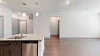 Located at 404 Gallop Ln in Charlotte, NC, this well-appointed single-floor residence offers a clean, modern aesthetic throughout. The open-concept kitchen serves as the heart of the home, showcasing granite countertops, a central island with a built-in sink, pendant lighting, rich dark cabinetry, a subway tile backsplash, and a full suite of stainless steel appliances including a refrigerator, range, microwave, and dishwasher. Hardwood-style flooring flows seamlessly throughout the entire space, complementing the neutral, light-toned walls and crisp white trim.

The bedrooms are generously sized, each featuring natural light through slatted-blind windows and ceiling fans for year-round comfort. The primary bathroom impresses with a dual-sink granite vanity, a large framed mirror, and a glass-enclosed walk-in shower, while a secondary bathroom offers a full tub-shower combination. A spacious walk-in closet with wire shelving provides abundant storage.

A dedicated laundry room houses a full-size washer and dryer with additional wire shelving above. The overall layout is thoughtfully designed, offering both functionality and a contemporary feel throughout every area of the home.