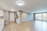 Located at 1910 Chestnut Ave in Glenview, IL, this well-appointed 2-bedroom, 2-bathroom residence offers a thoughtfully designed single-floor layout. The open-concept main living area seamlessly integrates the living room, dining area, and kitchen, all finished with light-toned hardwood-style flooring and neutral gray walls that create a clean, contemporary atmosphere. Natural light flows in through a set of glass French doors in the living area, enhancing the sense of openness.

The kitchen is outfitted with white shaker cabinetry, light quartz countertops, a subway tile backsplash, and stainless steel appliances including a gas range and over-the-range microwave. Both bathrooms are finished with matching light wood-look flooring and white vanities with ample storage. One bathroom features a tub-shower combination, while the other offers a glass-enclosed walk-in shower. The spacious primary bedroom includes hardwood-style flooring and generous natural light, while the second bedroom features plush carpeting and a large window. Three closets, a dedicated laundry area, and a connecting hallway complete this practical and modern layout.