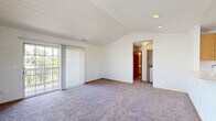 Located at 51 Great Trail Circle in Pickerington, Ohio, this single-floor, two-bedroom, two-bathroom home offers a practical and comfortable layout. The kitchen is equipped with warm honey-oak cabinetry, white countertops, and black appliances including a range, over-the-range microwave, and refrigerator. Light-colored wood-look flooring and bright windows with outdoor views lend the kitchen an airy, functional feel. The spacious living area features soft carpeting, vaulted ceilings, and a sliding glass door that opens to a balcony overlooking greenery, filling the space with natural light. The primary bedroom is generously sized with plush carpeting, vaulted ceilings, and direct access to an en-suite bathroom featuring a vanity with oak cabinetry. A walk-in closet with wire shelving provides ample storage. The second bedroom offers carpeted flooring and a large window with pleasant outdoor views. The second full bathroom includes a tub/shower combo with clean white surrounds and wood-look flooring. A hallway connects all rooms, and two closets throughout the home ensure convenient storage. The overall ambiance is clean, bright, and move-in ready.