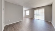 Located at 1302 Pine Cove Circle in Virginia Beach, Virginia, this single-floor residence offers a practical and well-appointed layout designed for comfortable everyday living. The open-concept living and dining area is finished with light wood-look flooring and neutral gray walls, creating a bright, versatile space. A sliding glass door flanked by vertical blinds and an additional window allow natural light to fill the room while providing direct access to outdoor views.

The galley-style kitchen is efficiently designed with rich, dark cabinetry accented by brushed nickel hardware and light granite-style countertops. Stainless steel appliances, including a range, over-the-range microwave, and refrigerator, complement the space, while light wood-look flooring carries throughout. The kitchen opens toward the living area, maintaining a connected feel.

The bedroom features plush carpeting, soft gray walls, and ample natural light from a window. Two side-by-side closets with built-in shelving provide generous storage. The bathroom is clean and functional, featuring a full tub-shower combination with white surround, brushed nickel fixtures, and wood-look tile flooring. The overall aesthetic throughout is neutral, cohesive, and move-in ready.