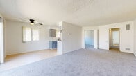 Located at 5189 Revere St in Chino, California, this single-story, 2-bedroom, 1-bathroom home offers a practical and comfortable layout throughout. The open living and dining area is finished with plush gray carpeting and features a ceiling fan, a textured ceiling, and a sliding glass door that fills the space with natural light and provides direct access to a private patio. The galley-style kitchen is equipped with gray cabinetry, light countertops, a stainless steel sink, and black appliances including a gas range with overhead ventilation — all set on light wood-look flooring. A hallway connects the main living areas to the bedrooms and bathroom. The spacious primary bedroom offers ample room and includes two closets — one a built-in cabinet-style closet and the other a walk-in closet with built-in shelving and hanging rods. The second bedroom features carpet flooring and a window with outdoor views. The full bathroom is finished with white tile surrounding a soaking tub and shower combo. Each bedroom benefits from natural light via windows. The home's clean, neutral palette and functional layout make it a well-organized and move-in ready space.