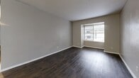 Located at 834 Timberlake Cir in Arlington, TX, this single-story unit offers three bedrooms and two bathrooms across a well-organized floor plan. Dark hardwood-style flooring runs throughout the home, providing a cohesive and polished look in every room.

The living room is a comfortable, open space featuring a large window with blinds that brings in natural light and offers views of the surrounding exterior. The galley-style kitchen is efficiently designed with gray lower and upper cabinetry, white countertops, a subway tile backsplash, and black appliances including a refrigerator and range. A bright overhead light keeps the space well-lit.

The spacious primary bedroom features dark flooring, neutral gray walls, and a dedicated closet. The two additional bedrooms are each equipped with ceiling fans, windows for natural light, and closets, making them versatile spaces suitable for sleeping, working, or other uses. All three bedrooms are connected via a central hallway.

The two bathrooms offer clean, functional layouts. One includes a marble-style vanity countertop with a mirror and window, while the second features a full tub-shower combo with white tile surround. Both maintain a bright, neutral aesthetic consistent with the rest of the home.