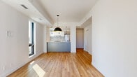 Located at 600 Mountaineer Pvt in Ottawa, this modern 2-bedroom, 1-bathroom unit offers a thoughtfully designed open-concept layout finished with warm light wood flooring throughout. The combined living, dining, and kitchen area serves as the heart of the home, anchored by a striking kitchen featuring a two-tone design with white upper cabinetry, slate-grey lower cabinets, a white quartz peninsula with an integrated sink, stainless steel appliances, a tile backsplash, and a sleek range hood. Stylish pendant lighting — including a bold dome fixture with a gold interior — adds a contemporary accent. Large black-framed windows invite abundant natural light into the living area, which also features a built-in fireplace. Both bedrooms are bright and well-proportioned, each offering large windows with urban views and sliding closet doors for ample storage. The bathroom is finished in a clean, modern palette with large-format grey tile flooring, a glass-enclosed walk-in shower, a floating white vanity with an undermount sink, and recessed lighting. A dedicated laundry area and a hallway with additional closets round out the well-organized floor plan, making this a highly functional and stylish urban residence.