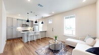 Located in San Antonio, TX, this thoughtfully designed two-story home offers 1 bedroom and 2 bathrooms across two equally sized floors. The main level features a bright, open-concept living and dining area with warm hardwood-style flooring, large windows that invite natural light, and a seamless flow into the kitchen. The kitchen is a standout feature, showcasing grey shaker cabinetry, white subway tile backsplash, sleek quartz countertops, stainless steel appliances, and a peninsula with bar seating illuminated by striking black pendant lights. A convenient half bathroom on the main floor includes a pedestal sink and matte black fixtures, adding a modern touch. Upstairs, the spacious primary bedroom is carpeted for comfort and features a ceiling fan, multiple windows offering natural light, and a generous walk-in closet with built-in shelving and hanging rods. The full bathroom on this level is finished with large-format tile flooring, a soaking tub with shower, a white vanity, and coordinating matte black hardware throughout. The home's clean, neutral palette and contemporary detailing create a cohesive and inviting atmosphere from top to bottom.