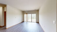 Located at 301 E Main St in Waunakee, WI, this well-appointed 2-bedroom, 2-bathroom unit offers a thoughtfully designed single-level floor plan. The open-concept kitchen and living area serves as the heart of the home, showcasing rich dark-stained cabinetry, granite countertops, a peninsula with pendant lighting, and a full suite of stainless steel appliances including a refrigerator, range, microwave, and dishwasher. Wood-style luxury vinyl plank flooring flows throughout the kitchen and living areas, adding warmth and durability. The spacious living room is filled with natural light and features sliding glass doors that open to a private balcony with outdoor views. Both bedrooms are carpeted and offer windows that bring in additional natural light. The primary bedroom is generously sized and connects to a bathroom with a walk-in shower. A second full bathroom features a soaking tub/shower combination, a dark-stained vanity, and matching wood-style flooring. A dedicated closet with built-in shelving and hanging rods provides practical storage. Neutral tones and clean finishes throughout create a bright, move-in-ready atmosphere suited for comfortable everyday living.