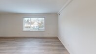 Located at 3901 Boonsboro Rd in Lynchburg, Virginia, this single-floor, one-bedroom, one-bathroom residence offers a clean, modern aesthetic with thoughtfully updated finishes throughout. The open-concept kitchen and living area serves as the heart of the home, featuring light wood-style luxury vinyl flooring, crisp white walls, and crown molding details. The kitchen is well-appointed with white shaker-style cabinetry, light quartz countertops, a stainless steel undermount sink, and a full suite of stainless steel appliances including a refrigerator, electric range, microwave, and dishwasher. Recessed lighting keeps the space bright and functional. The living room is generously sized, bathed in natural light from large windows fitted with blinds that offer outdoor views of the surrounding neighborhood. The spacious primary bedroom is carpeted for comfort and includes a double-door closet, a window for natural light, and direct access to the rest of the unit. The full bathroom presents a clean, all-white design with a tub/shower combo, chrome fixtures, built-in shelving, a white vanity, and light wood-style tile flooring. This residence combines practical functionality with modern, neutral finishes throughout.