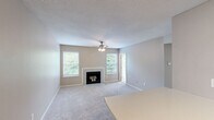 Located in Cincinnati, OH, this efficient one-bedroom, one-bathroom unit offers a well-organized single-floor layout. The living room is a welcoming focal point, featuring a classic fireplace framed by a white mantel, soft carpeting, a ceiling fan with light fixture, and a textured ceiling. Multiple windows flood the space with natural light, and a sliding glass door opens directly onto a private outdoor balcony with wooded views, extending the living area outdoors. The kitchen is compact and functional, equipped with white cabinetry, wood-toned accents, a double-basin sink, electric range, and durable wood-look flooring — providing all essential amenities in an efficient footprint. The bedroom is a comfortably sized retreat with plush carpeting and neutral-toned walls. It includes access to a dedicated walk-in closet with built-in shelving, offering generous storage. The bathroom features a full tub-shower combination with white tile surround, a large vanity mirror, multi-bulb light fixture, and a clean, classic finish. Throughout the unit, a consistent neutral color palette and soft carpeting create a calm, cohesive ambiance. The private balcony with its scenic greenery adds an appealing outdoor connection to this Cincinnati residence.