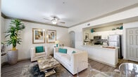 Located in Stafford, TX, this 2-bedroom, 1-bathroom residence offers a well-designed, single-story layout that maximizes every inch of its cozy footprint. The open-concept living and dining area is bright and welcoming, featuring wood-look flooring, crown molding, a ceiling fan, and a sliding glass door that opens to a private patio, allowing natural light to fill the space. The living area provides ample room for comfortable seating and a dining nook with a sleek glass table.

The galley-style kitchen is thoughtfully appointed with white shaker cabinetry, quartz countertops, a subway tile backsplash, and a full suite of stainless steel appliances, including a refrigerator, range, microwave, and dishwasher. A built-in desk nook with white cabinetry and wood-look flooring offers a functional workspace or study area.

The primary bedroom features plush carpeting, a ceiling fan, and a natural light-filled window, creating a restful retreat. The second bedroom is equally comfortable. The bathroom is clean and modern, with white cabinetry, quartz countertops, wood-look flooring, a tub-shower combination, and direct access to a spacious walk-in closet with built-in shelving.