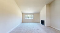 This single-story, 2-bedroom, 1-bathroom home on W Benjamin Holt Drive in Stockton, California offers a well-organized layout with comfortable living spaces throughout. The living room is a standout feature, boasting soaring vaulted ceilings that amplify the sense of space, neutral carpet flooring, and a classic fireplace flanked by a large window that fills the room with natural light and offers views of the surrounding greenery. Adjacent to the living room, the dining area transitions seamlessly to the kitchen via a pass-through bar opening, with a ceiling fan overhead adding functionality. The kitchen features wood-look flooring, white cabinetry, and includes appliances such as a refrigerator and dishwasher, with a window providing additional natural light. The spacious primary bedroom includes a sliding glass door leading to an outdoor patio area, offering convenient exterior access. The second bedroom, also carpeted, connects directly to the kitchen area. The full bathroom is cleanly appointed with wood-look flooring, a single-sink vanity with light countertops, a full tub-shower combination, and a large mirror. The home's warm, neutral color palette and consistent finishes create a cohesive and inviting atmosphere throughout.