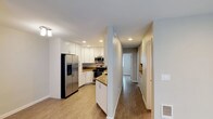 This single-story unit at 3131 Cauby St, Unit 71 in San Diego presents a clean, contemporary interior with a cohesive design throughout. Wood-look flooring runs consistently across the main living areas, bedrooms, and hallways, contributing to a warm, unified aesthetic.

The kitchen is a standout feature, offering white shaker-style cabinetry with ample upper and lower storage, granite-look countertops, and a full suite of stainless steel appliances including a French door refrigerator with water and ice dispenser, electric range, microwave, and dishwasher. Recessed lighting illuminates the space effectively. The kitchen connects to the main living area, which benefits from recessed lighting and a sliding glass door that allows natural light and provides outdoor access.

The bedrooms are comfortably scaled, each featuring wood-look flooring, a ceiling fan with light fixture, and windows with blinds offering views of surrounding greenery. The bathrooms feature white vanities with granite-look countertops, framed mirrors, and brushed nickel fixtures. At least one bathroom includes a tub-shower combination with a smooth surround. The unit also features a dedicated hallway with built-in storage, and an entry area that flows openly toward the kitchen.