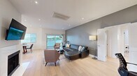 Located on Thayer Avenue in the desirable West Los Angeles neighborhood of 90025, this thoughtfully designed 3-bedroom, 2-bathroom home offers a clean, contemporary aesthetic across a single, well-organized floor. Light hardwood flooring flows through the main living areas, complementing a bright, open-concept layout that seamlessly connects the living room, dining area, and kitchen. The spacious living room features a bold grey accent wall, a fireplace, recessed lighting, and sliding glass doors that lead to a private balcony with outdoor seating — filling the space with natural light and lush greenery views. The dining area is anchored by a large picture window and comfortably seats six. The sleek, all-white kitchen is equipped with stainless steel appliances, handleless cabinetry, and quartz countertops. The generously sized primary bedroom includes a dedicated accent wall and a well-appointed walk-in closet with custom shelving, drawers, and built-in organizers. Two additional bedrooms offer ample natural light and closet space, ideal for guests or a home office. Both bathrooms are finished with large-format tile and glass-enclosed tub-shower combinations. A tucked-away laundry area with full-size washer and dryer adds everyday convenience to this polished West LA home.