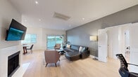 Located on Thayer Avenue in the desirable West Los Angeles neighborhood of 90025, this thoughtfully designed 3-bedroom, 2-bathroom home offers a clean, contemporary aesthetic across a single, well-organized floor. Light hardwood flooring flows through the main living areas, complementing a bright, open-concept layout that seamlessly connects the living room, dining area, and kitchen. The spacious living room features a bold grey accent wall, a fireplace, recessed lighting, and sliding glass doors that lead to a private balcony with outdoor seating — filling the space with natural light and lush greenery views. The dining area is anchored by a large picture window and comfortably seats six. The sleek, all-white kitchen is equipped with stainless steel appliances, handleless cabinetry, and quartz countertops. The generously sized primary bedroom includes a dedicated accent wall and a well-appointed walk-in closet with custom shelving, drawers, and built-in organizers. Two additional bedrooms offer ample natural light and closet space, ideal for guests or a home office. Both bathrooms are finished with large-format tile and glass-enclosed tub-shower combinations. A tucked-away laundry area with full-size washer and dryer adds everyday convenience to this polished West LA home.
