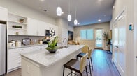 Located at 600 E North Grove Blvd in Waxahachie, TX, this well-appointed one-bedroom, one-bathroom residence offers a smart, efficient layout across a single floor. The open-concept design connects the kitchen and living area seamlessly, creating an inviting and functional living space.

The kitchen is a standout feature, showcasing crisp white shaker cabinetry, granite countertops, stainless steel appliances including a side-by-side refrigerator and microwave, and a generous island with bar seating and pendant lighting overhead. Wood-look flooring runs throughout, adding warmth and continuity to the space.

The living room is bright and welcoming, benefiting from a large window and a private exterior door that brings in natural light and outdoor access. The bedroom is a comfortable retreat with a natural light-filled window, wood-look flooring, and access to a dedicated closet. A pantry and hallway further enhance the home's storage and flow.

The bathroom is finished with a granite-topped vanity, white cabinetry, and a tub-shower combination. Throughout the residence, neutral tones, recessed lighting, and clean architectural lines create a modern yet comfortable ambiance well-suited for everyday living.