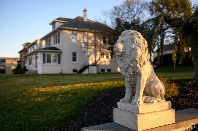 A concrete lion stands watch in Lansdale residential neighborhood.