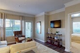 This single-story residence offers a thoughtfully designed layout that balances comfort and functionality throughout its well-appointed rooms. The living area serves as the central gathering space, featuring rich hardwood-style flooring, crown molding, and a neutral warm-toned color palette. A glass-paneled exterior door floods the room with natural light while providing outdoor views, and the space comfortably accommodates a sectional sofa arrangement alongside decorative shelving.

Adjacent to the living area, the dining space continues the hardwood-style flooring and crown molding detail, offering a dedicated area for meals with convenient access to the kitchen. The kitchen is well-equipped with dark espresso cabinetry, light granite-style countertops, stainless steel appliances including a refrigerator, electric range, and built-in microwave, as well as a window above the sink that introduces natural light.

The bedrooms are carpeted for comfort, each featuring large windows with outdoor views and ample space for furnishings. The bathroom mirrors the kitchen's dark cabinetry and granite-style countertops, and benefits from multiple windows that brighten the space. Hardwood-style flooring extends through the bathroom, tying together the overall design cohesively.