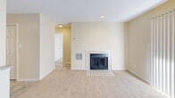 Located at 2515 Potomac Hunt Ln in Henrico, Virginia, this single-floor, one-bedroom, one-bathroom residence offers a well-organized layout across a compact yet efficient floor plan. The living room serves as the heart of the home, highlighted by a classic tile-surround fireplace with glass doors and soft carpeting underfoot. A sliding glass door with vertical blinds fills the space with natural light and provides access to the outdoors. Adjacent to the living area, the dining space features tile flooring and chair-rail molding, adding a subtle architectural detail to the neutral, warm-toned walls. The kitchen is outfitted with warm wood cabinetry, granite-style countertops, a double-basin stainless steel sink, and a full-size refrigerator, offering functional storage and workspace. The bedroom is a comfortable, light-filled retreat with plush carpet, a large window with blinds, and direct access to a dedicated closet. The full bathroom includes a single-vanity with wood cabinetry, a white countertop, a wall-mounted mirror, and a full-size soaking tub with shower combination featuring a safety grab bar. Throughout the home, consistent warm beige tones and clean white trim create a cohesive and inviting ambiance.