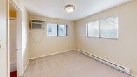 Located at 711 E Sharp Ave in Spokane, WA, this one-bedroom, one-bathroom unit offers a well-organized layout across a single floor. The kitchen is equipped with warm wood cabinetry, a full-size refrigerator, electric range, built-in microwave, and a double sink — all set atop easy-care hardwood-style flooring. A textured ceiling and overhead lighting complete the functional cooking space. The bedroom features plush carpeting, two windows that allow natural light to fill the room, a wall-mounted air conditioning unit, and baseboard heating for year-round comfort. A generously sized double-door closet provides ample storage. The bathroom includes a wood-toned vanity with a light granite countertop, a large mirror with overhead lighting, and a full shower-tub combination, all finished with hardwood-style flooring. Neutral, warm beige tones carry throughout the unit, creating a cohesive and calm ambiance. The textured ceilings and clean white trim add a classic touch to the overall aesthetic, making this a practical and comfortable space in the heart of Spokane.