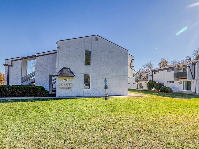 Charming apartment building with modern architecture, nestled in a serene neighborhood with lush green lawns. - Elk Mountain Apartments