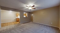 Located at 1126 W Cato Springs Rd in Fayetteville, Arkansas, this single-floor unit offers a well-organized layout designed for comfortable everyday living. The living area is generously sized, featuring neutral-toned carpet, a ceiling fan with integrated lighting, and a textured ceiling. A pass-through window connects the living space directly to the kitchen, creating an open, communicative flow between the two areas.

The kitchen is designed in a galley configuration, outfitted with warm oak-toned cabinetry, granite-style countertops, hardwood-style flooring, and white appliances including a range, refrigerator, and dishwasher. Ample upper and lower cabinet storage makes the kitchen both functional and practical.

The unit includes multiple bedrooms, each finished with plush carpet, ceiling fans, and natural light from windows fitted with horizontal blinds. The rooms offer generous wall space suitable for varied furniture arrangements.

Two full bathrooms serve the unit, each featuring a tub-shower combination, hardwood-style flooring, and wood-toned vanity cabinetry with granite-style countertops, maintaining a consistent design aesthetic throughout.

Overall, the unit presents a cohesive, neutral color palette with warm wood accents, providing a practical and inviting living environment in a residential Fayetteville neighborhood.