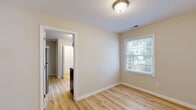 Located at 8 S Reed in Mobile, Alabama, this single-story, two-bedroom home offers a clean and functional layout with a cohesive design aesthetic throughout. Light wood-look flooring runs continuously across all rooms, complementing the soft, warm neutral tones of the walls and crisp white trim and baseboards that frame each space.

The primary bedroom is a well-proportioned room featuring smooth walls, a ceiling-mounted light fixture, and a window that allows natural light to filter in with views of surrounding greenery. The second bedroom is similarly appointed, offering its own window with outdoor views, making it a bright and versatile space. A dedicated closet provides convenient storage, adding to the home's practicality.

The kitchen is a standout area, featuring white shaker-style cabinetry, light stone-look countertops, a stainless steel electric range with an overhead exhaust hood, and a single-basin sink. A large window above the counter floods the kitchen with natural light and offers pleasant outdoor views. The white subway tile backsplash adds a clean, modern detail.

Throughout the home, the consistent use of light tones, natural light, and uniform flooring creates a bright, cohesive atmosphere. The straightforward single-floor layout ensures easy flow between rooms, making this a practical and move-in-ready residence.