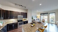 Located in the vibrant 78704 corridor of Austin, TX, this well-appointed one-bedroom, one-bathroom residence offers a thoughtfully designed open-concept floor plan. The kitchen serves as a central showpiece, boasting rich dark-espresso cabinetry, granite countertops, a tile backsplash, stainless steel appliances—including a refrigerator, range, and built-in microwave—and a peninsula island with bar seating, ideal for casual dining and entertaining. Track lighting overhead enhances both functionality and ambiance. Wood-style flooring flows seamlessly from the kitchen into the living area, where large floor-to-ceiling sliding glass doors and windows invite abundant natural light and provide direct access to a private balcony with open outdoor views. The bedroom is a comfortable retreat featuring plush carpet, dual windows, a ceiling fan, and a dedicated closet for ample storage. The full bathroom is finished with granite countertops, dark cabinetry, tile flooring, and a tiled tub-shower combination. Neutral wall tones throughout create a clean, modern backdrop, while recessed and track lighting ensure well-lit interiors. This residence combines practical design with contemporary finishes in one of Austin's most sought-after neighborhoods.