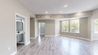Located at 764 Ridgeway Ave in Cincinnati, Ohio, this thoughtfully updated 3-bedroom, 2-bathroom home offers a clean, modern aesthetic across a single floor. Wood-look tile flooring in soft gray tones flows consistently throughout every room, tying the space together with a cohesive and contemporary feel.

The open living room is bright and welcoming, featuring vaulted ceilings, recessed lighting, and large windows that frame lush outdoor greenery. The kitchen is well-appointed with high-gloss white upper cabinets, contrasting gray lower cabinets, granite countertops, stainless steel appliances, and a matte black faucet — a stylish and functional workspace.

Each of the three bedrooms offers natural light through windows overlooking greenery, with ceiling fans and neutral gray walls creating a calm, comfortable atmosphere. The spacious primary bedroom includes a louvered closet and generous ceiling height. The two bathrooms are finished with modern details: one features a floating white vanity with a rectangular sink and matte black fixtures, while the other showcases a soaking tub surrounded by large-format marble-look tile with striking black hardware. A connecting hallway completes the efficient layout of this move-in-ready home.